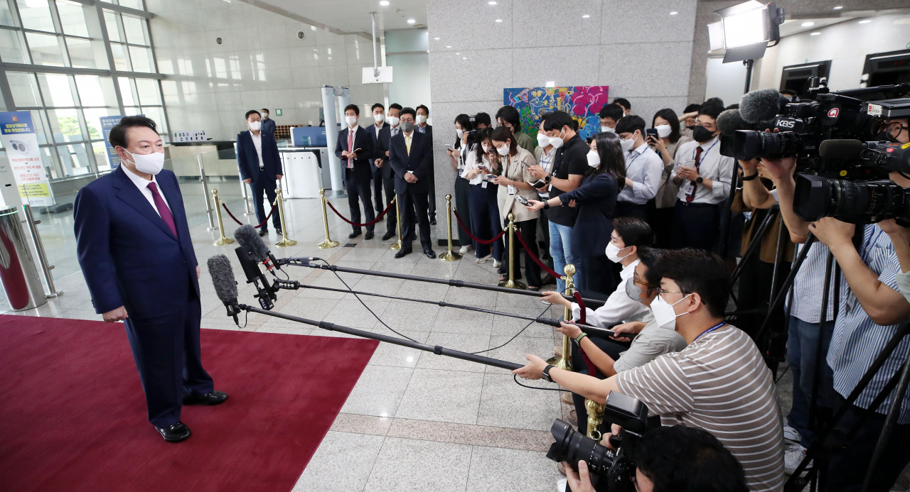 President Yoon Suk-yeol takes reporters' questions as he arrives at the presidential office in Seoul on Thursday. (Yonhap)