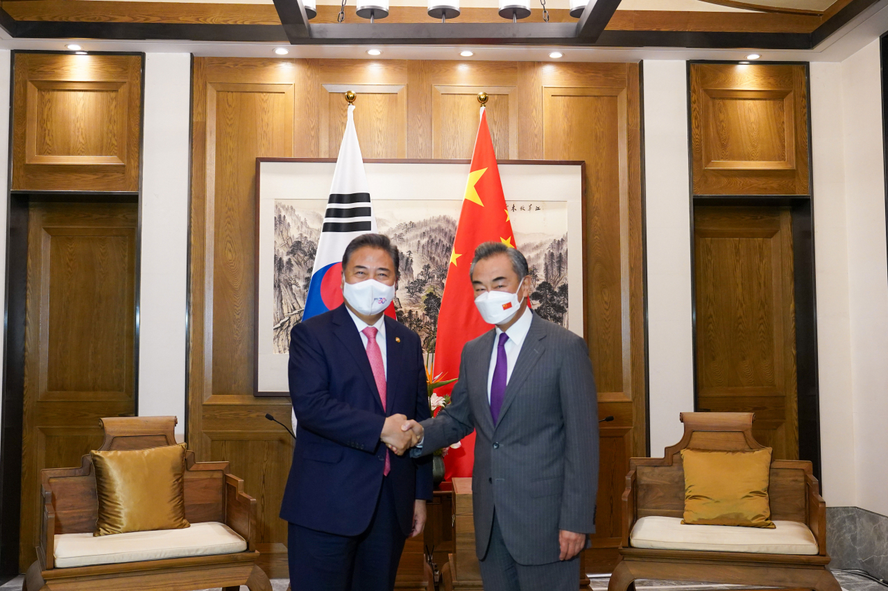 South Korean Foreign Minister Park Jin (L) poses for a photo with his Chinese counterpart, Wang Yi, prior to their talks in the eastern Chinese port city of Qingdao on Aug. 9, 2022, in this photo provided by the South Korean foreign ministry. (Yonhap)