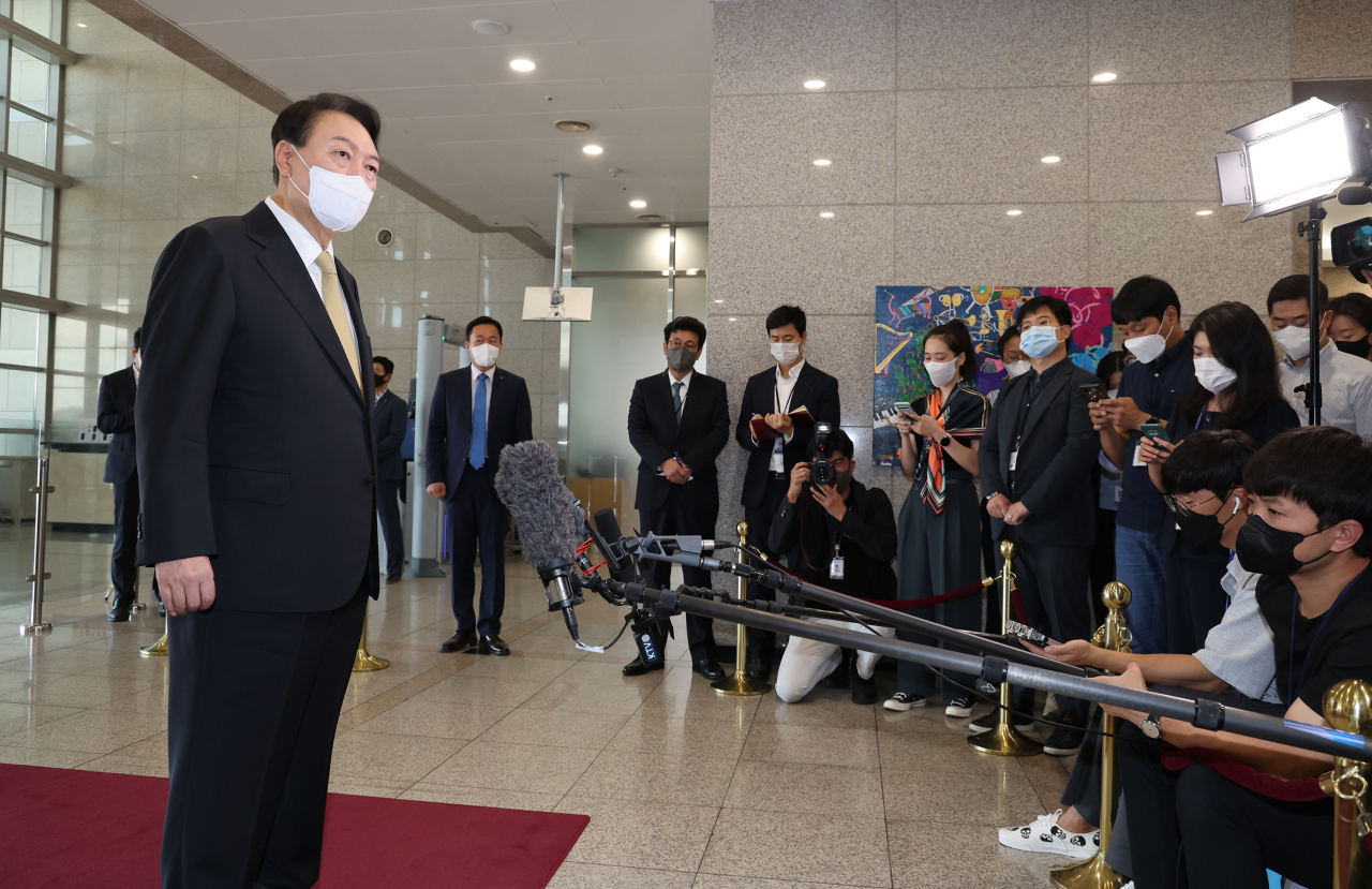 President Yoon Suk-yeol takes reporters' questions as he arrives at the presidential office in Seoul on Friday (Yonhap)