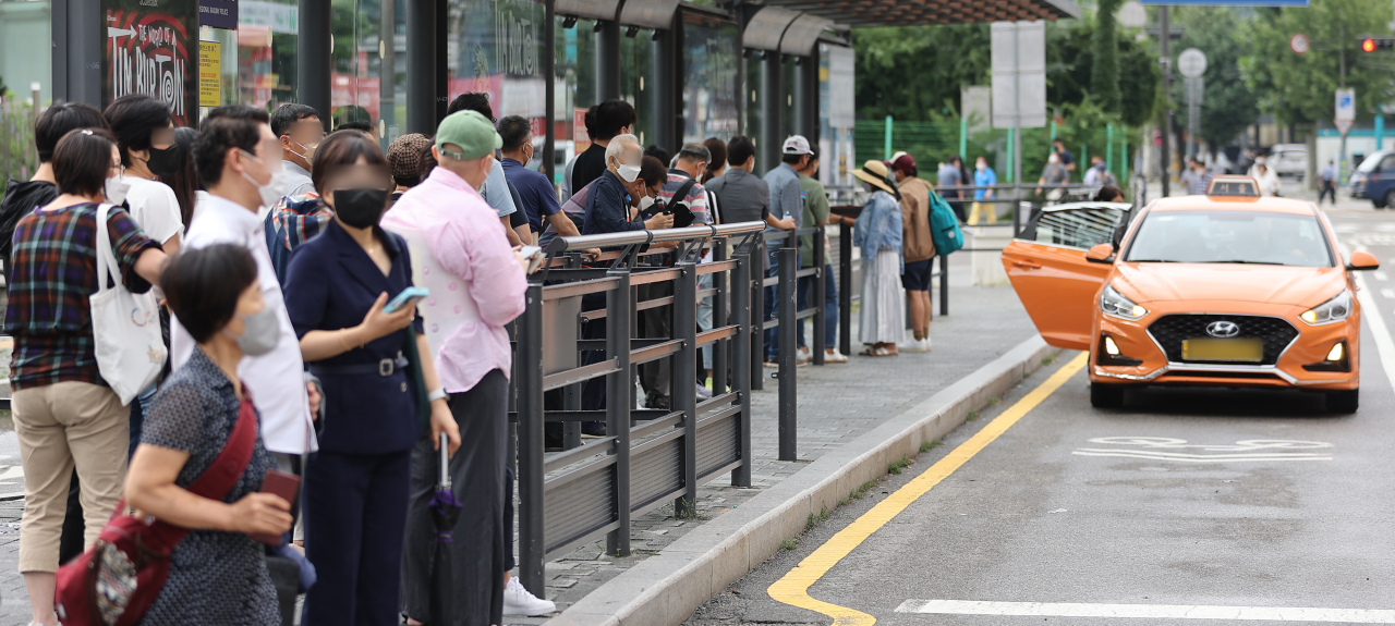 People line up at a taxi stand during rush hour in August near Seoul Station. (Yonhap)