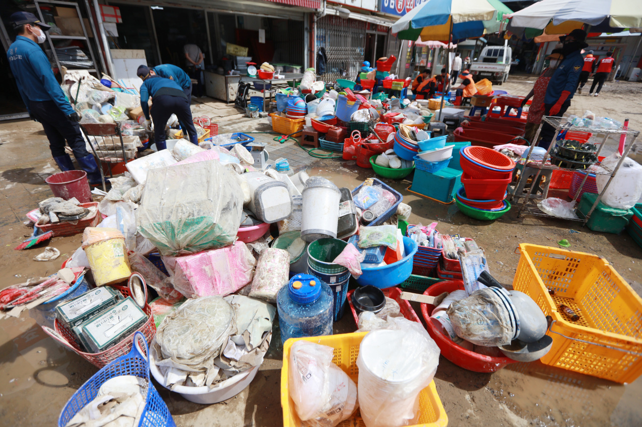Volunteer workers are washing up the merchandises at a tableware store in Ocheon Market in Pohang, North Gyeongsang Province, Thursday. (Yonhap)