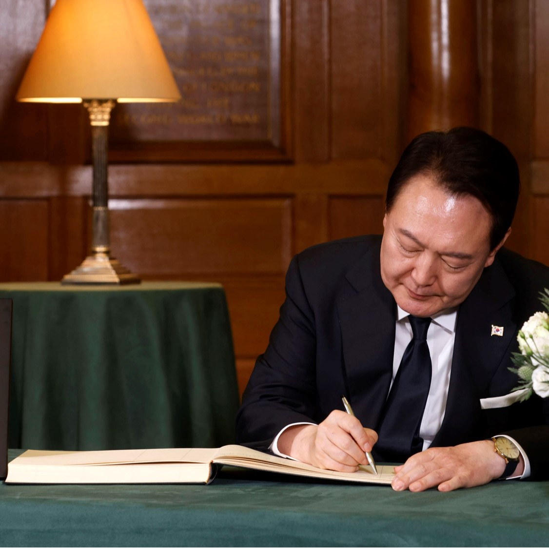 President Yoon Suk-yeol signs a condolence book for the queen at Church House. He wrote, 
