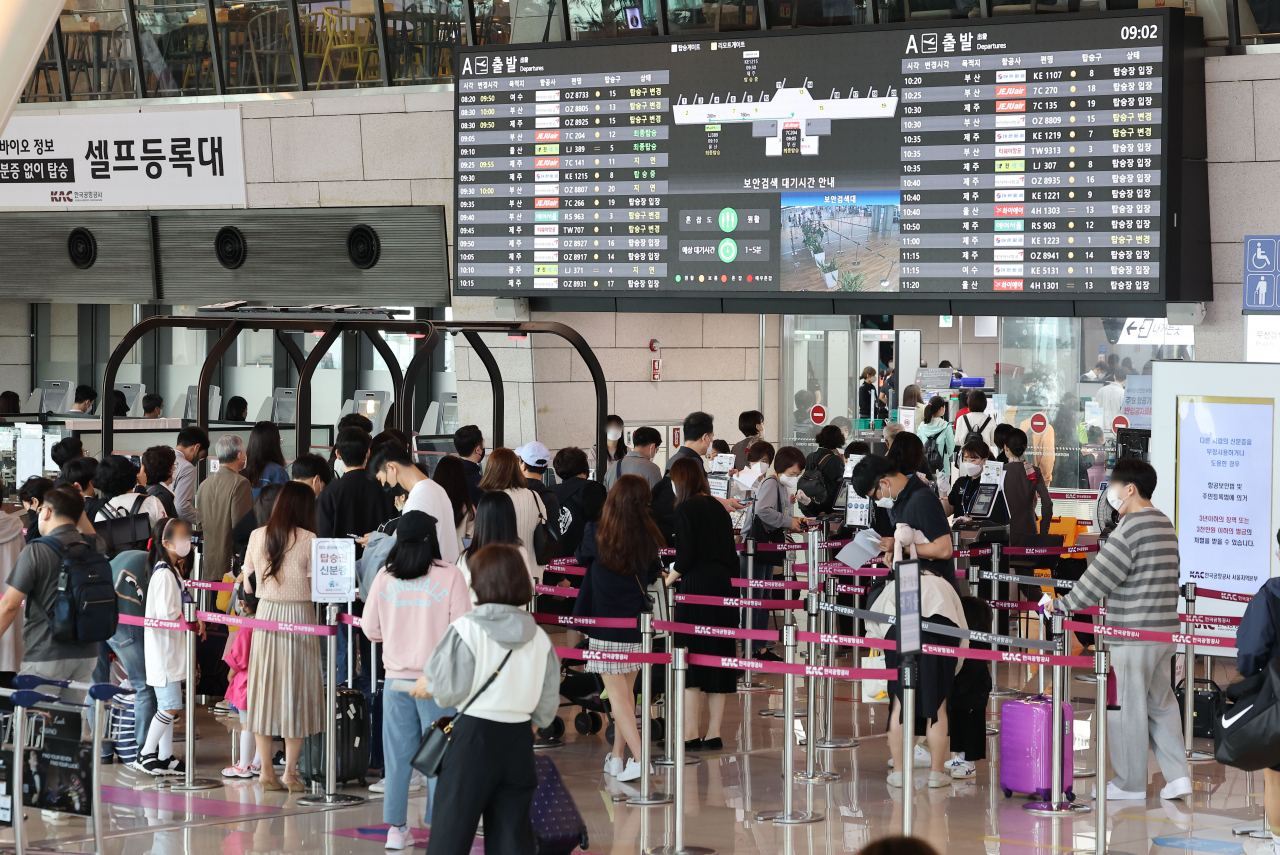 Passengers line up for check-in at Gimpo International Airport departures on Friday, just before South Korea's National Foundation Day holidays. (Yonhap)
