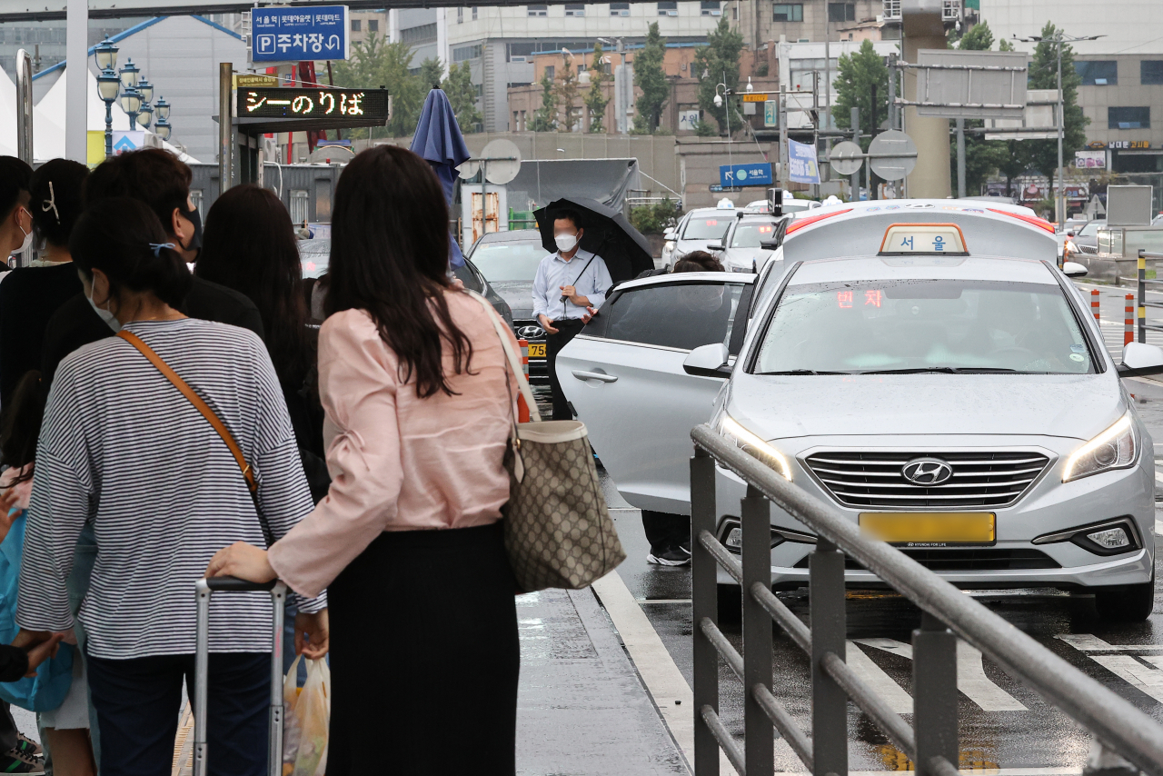 People waiting in line at a taxi stand in Seoul Station during rush hour on Tuesday. (Yonhap)