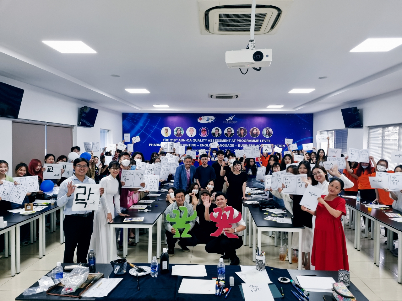Participants pose with their Korean writing at Lac Hong University in Vietnam, at a Hangeul Party event. (Hangeul Planet)
