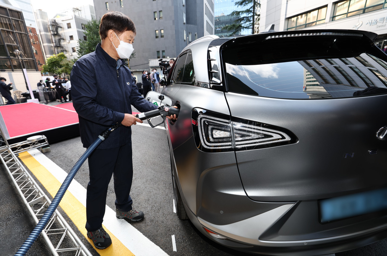 An official shows how to charge a hydrogen powered car at the Seoul Metropolitan Government Seosomun branch on Friday. (Yonhap)