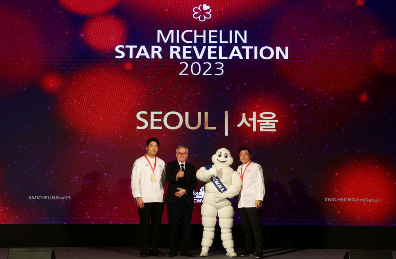 Three-star Michelin chefs, Kim Byoung-jin (right) and Anh Sung, pose with Jerome Vincon, managing director of Michelin Korea, at Vista Walkerhill Seoul, on Thursday (Michelin)