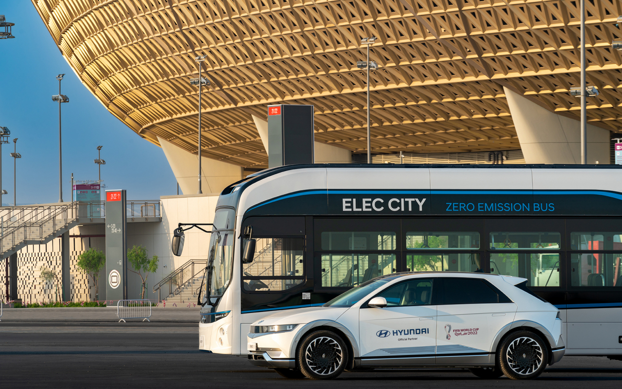 Hyundai Motor Group's eco-friendly vehicles Elec City and Ioniq 5 are parked in front of a soccer stadium in Doha, Qatar. (Hyundai Motor Group)