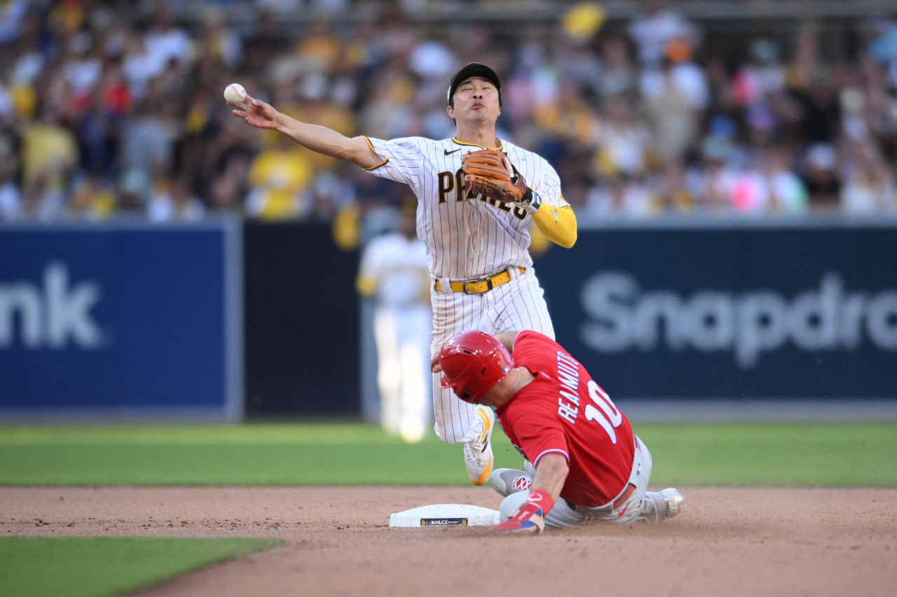 In this USA Today Sports photo provided via Reuters, San Diego Padres shortstop Kim Ha-seong (left) throws to first to complete a double play against the Philadelphia Phillies during the top of the eighth inning of Game 2 of the National League Championship Series at Petco Park in San Diego on Wednesday. (Yonhap)