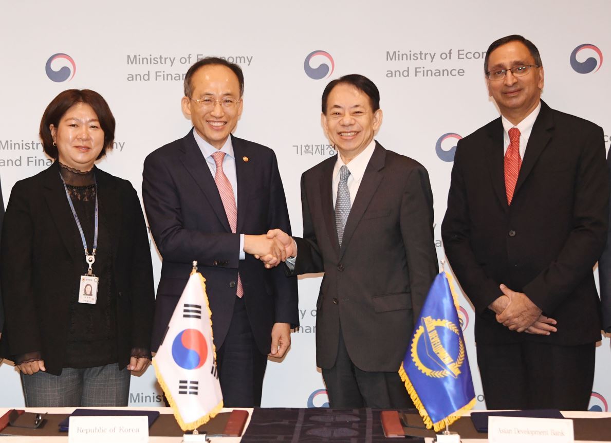 Deputy Prime Minister and Finance Minister Choo Kyung-ho (second from left) shakes hands with Asian Development Bank President Masatsugu Asakawa after signing a memorandum of understanding on bilateral collaboration in Seoul on Wednesday. (Ministry of Economy and Finance)