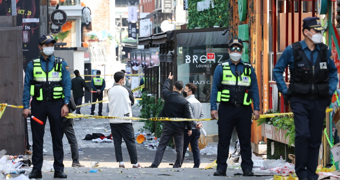 Police officers investigate the scene of the Itaewon crush on Sunday morning. (Yonhap)