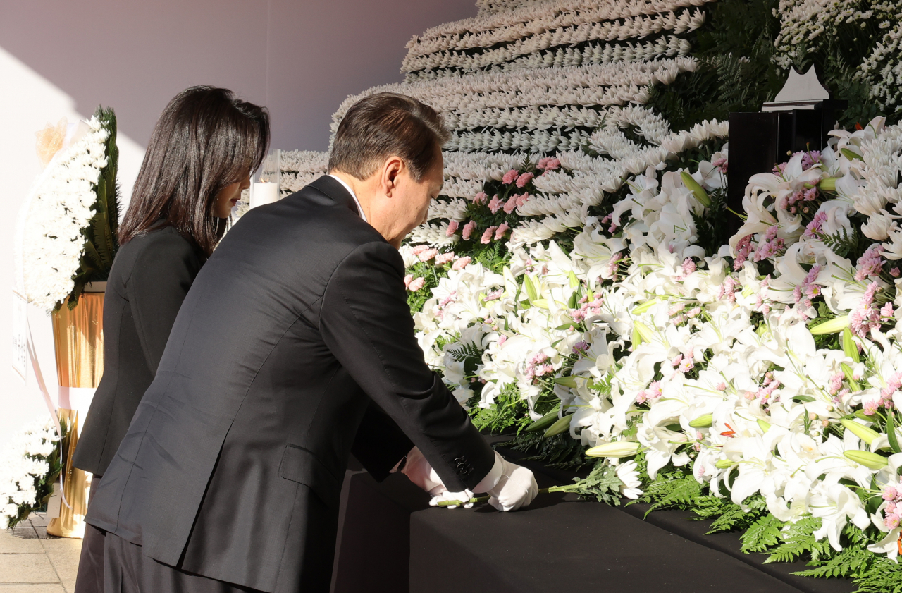 President Yoon Suk-yeol and first lady Kim Keon-hee visit a mourning altar for the victims of last weekend's Halloween crowd crush at Seoul Plaza in central Seoul on Monday. (Yonhap)