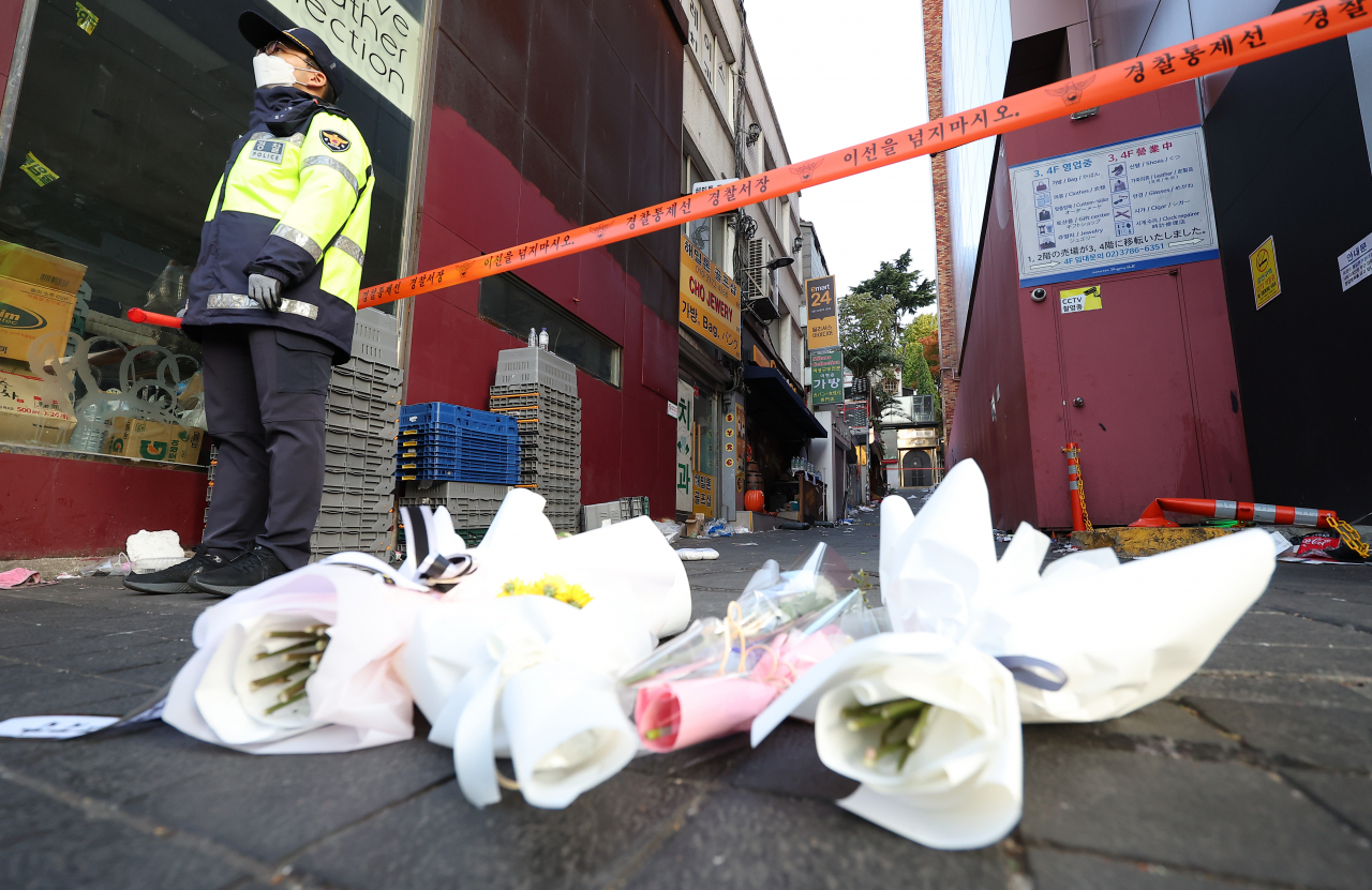 Flowers are laid at the entrance of an alleyway in Itaewon in Seoul on Monday morning, where a crowd surge left at least 154 people dead on Saturday night. (Yonhap)