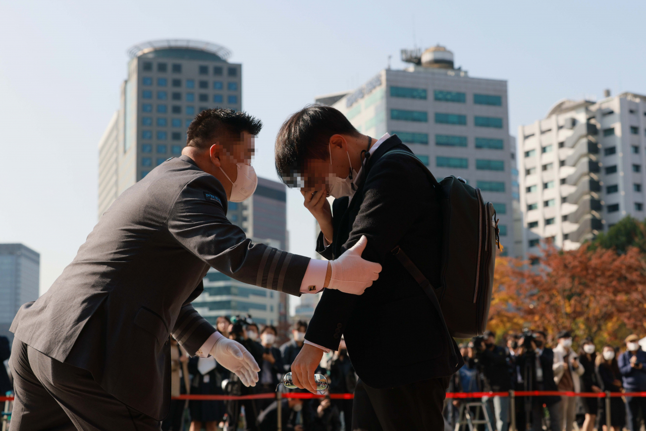 A mourner is escorted out after paying his respects to the victims of the Itaewon stampede at an altar for the Itaewon disaster victims set up in the front of Seoul City Hall on Monday morning. (Yonhap)