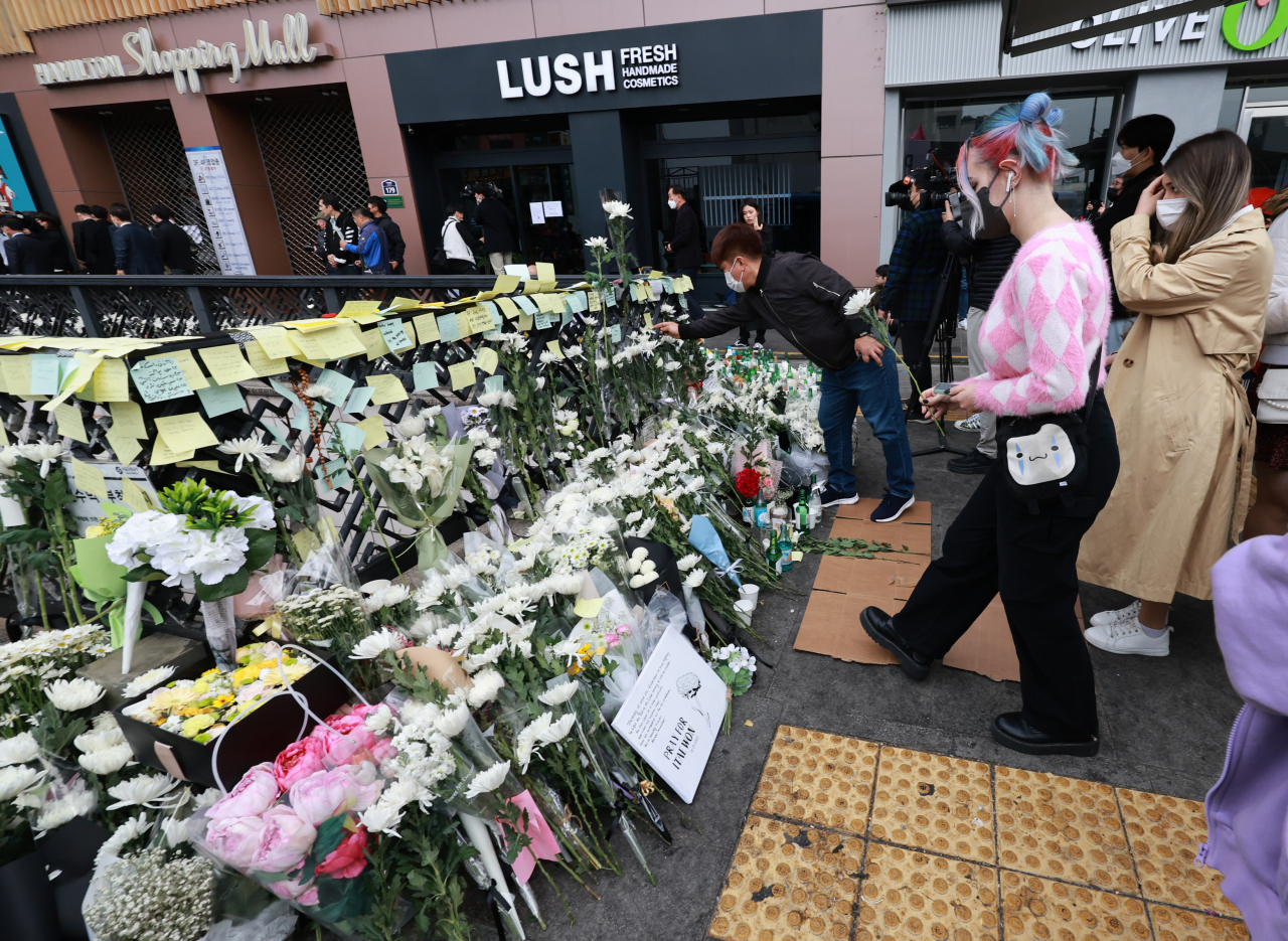 Mourners place white flowers to pay condolences at a memorial set up at Itaewon Station in central Seoul, Tuesday, for the victims of Saturday's deadly crowd crush that killed 156 people, including 26 foreign nationals. (Yonhap)