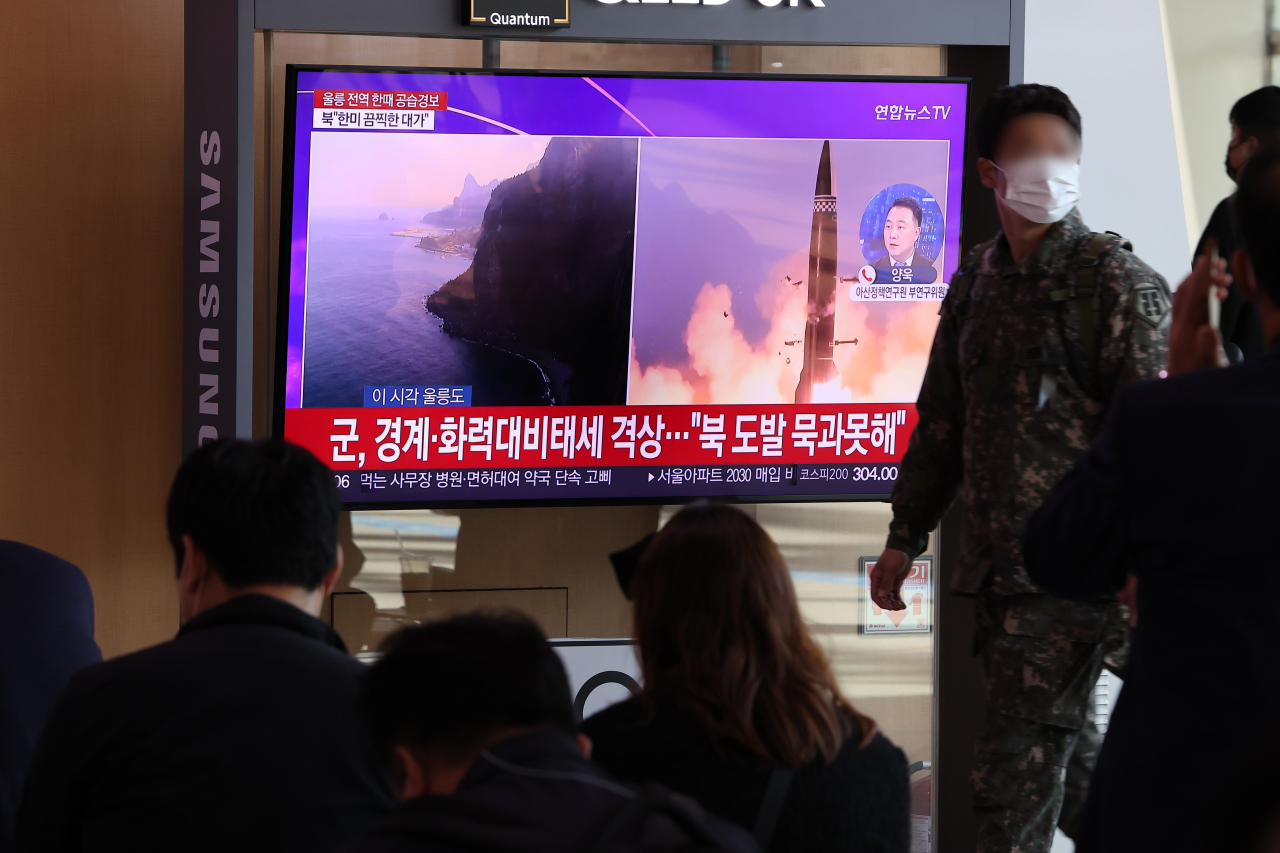 Citizens watch news related to North Korea's ballistic missile launch at Seoul Station on Wednesday morning. (Yonhap)