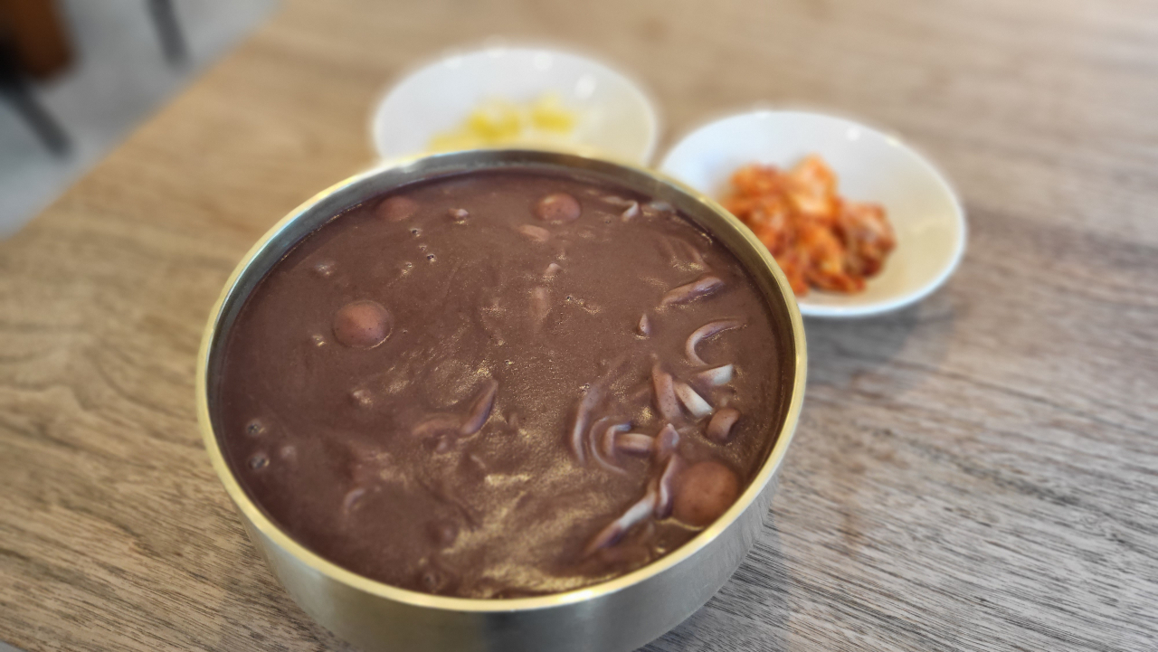 A bowl of patkalguksu, served with two types of kimchi (Kim Hae-yeon/ The Korea Herald)