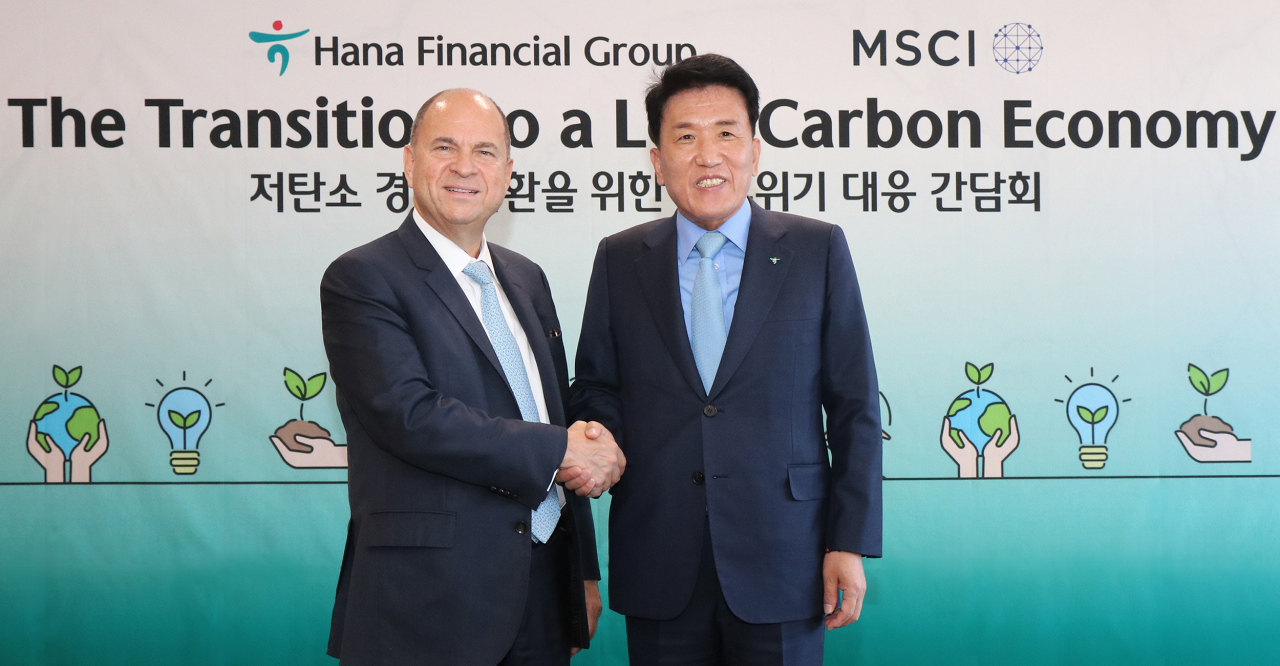 Hana Financial Group Chairman Ham Young-joo (right) poses for a photo with Morgan Stanley Capital International Chairman Henry Fernandez (left) follwing a meeting to discuss climate change response at Hana Financial Group's headquarters in Seoul, Friday. (Hana Financial Group)