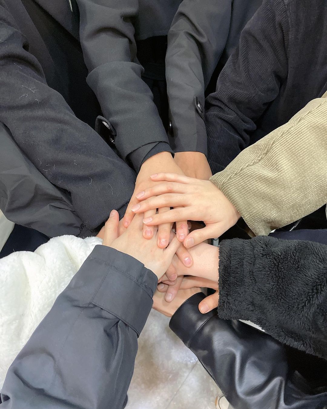 This image posted on Omega X's Instagram on Nov. 6 shows the hands of 11 members piled together. (Instagram @omega_x__for_x)