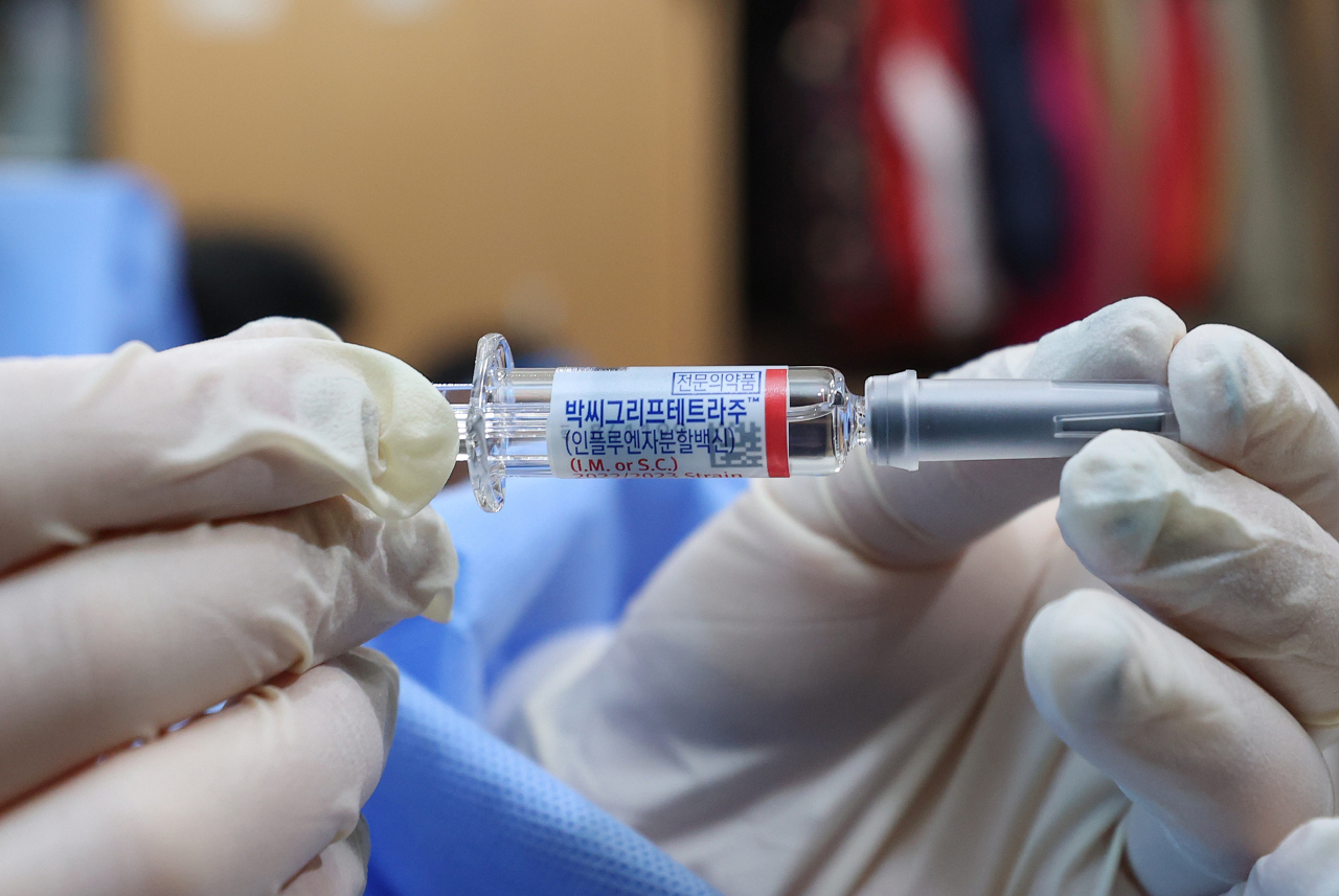 A medical worker holds up a vial of a vaccine at a public facility in Seoul on Oct. 18. (Yonhap)