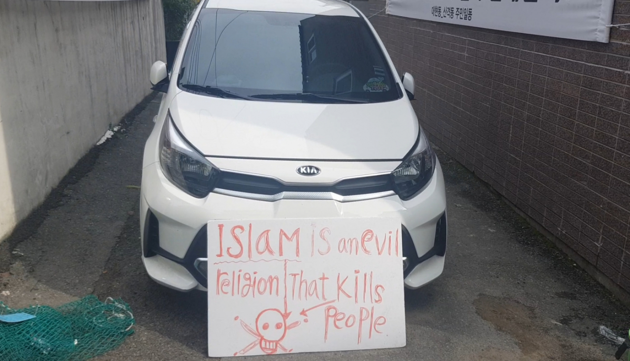 A sign in the front of a parked car reads “Islam is an evil religion that kills people.