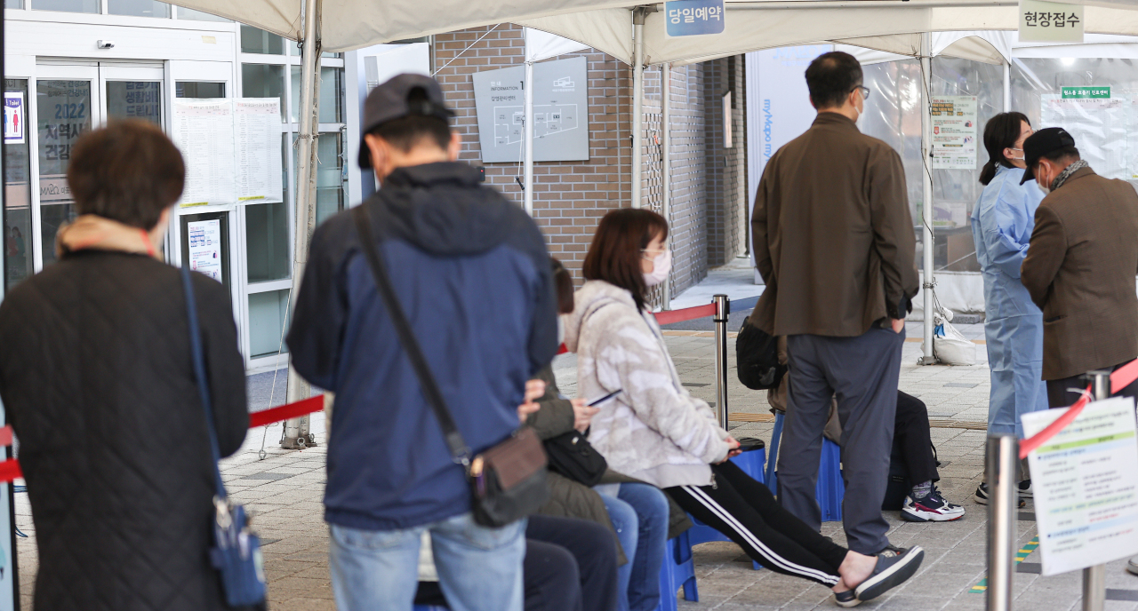 People line up to be tested for COVID-19 at a booth in Seoul. (Yonhap)