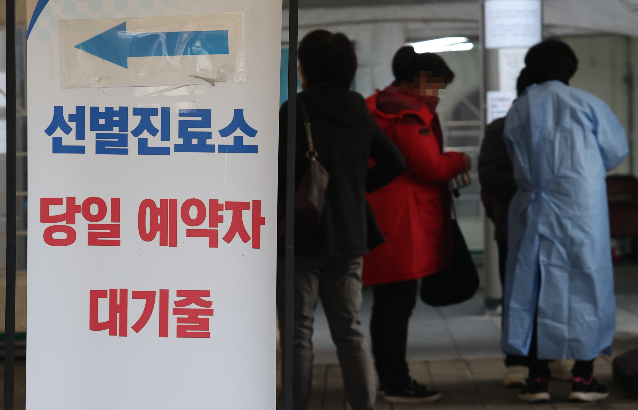 People line up to undergo COVID-19 tests at a makeshift testing station in Seoul on Wednesday. (Yonhap)
