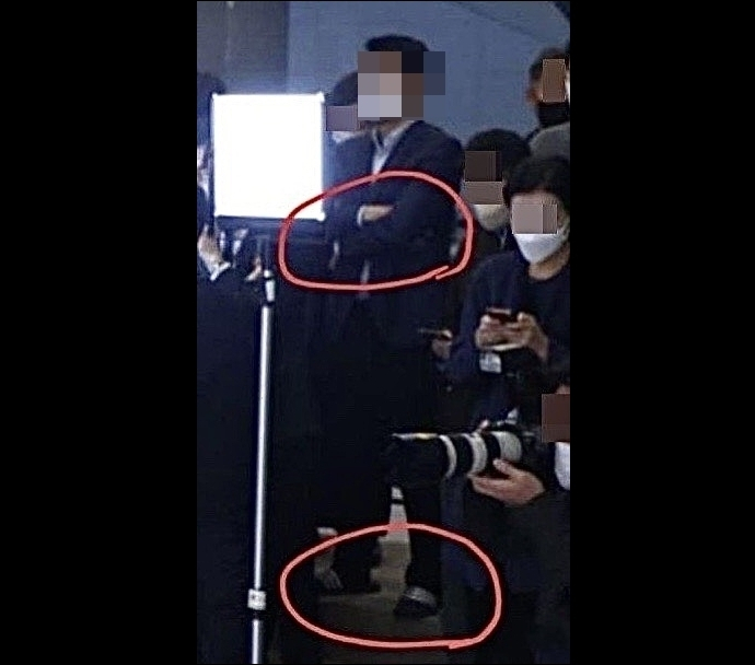 An MBC reporter stands at a press conference wearing slippers. (Kim's Facebook)