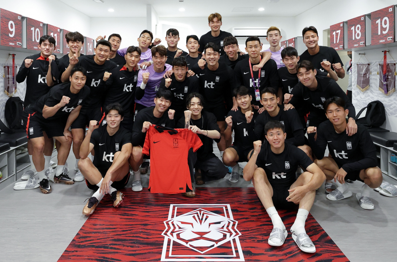 The South Korean national soccer team poses with Jungkook (front center) of BTS at the Al Egla training facility in Doha, Qatar, Saturday. The K-pop sensation performed at the opening ceremony for the FIFA World Cup Qatar on Sunday. (Yonhap)