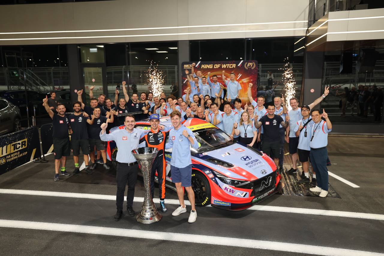 Hyundai Motor’s BRC Racing Team’s driver Mikel Azcona (center in the front row) and his team mates and crew pose for a photoshoot after winning the 2022 World Touring Car Cup held in Saudi Arabia’s Jeddah Corniche Circuit over the weekend. The team won championship titles in both driver and team awards. (Hyundai Motor Group)