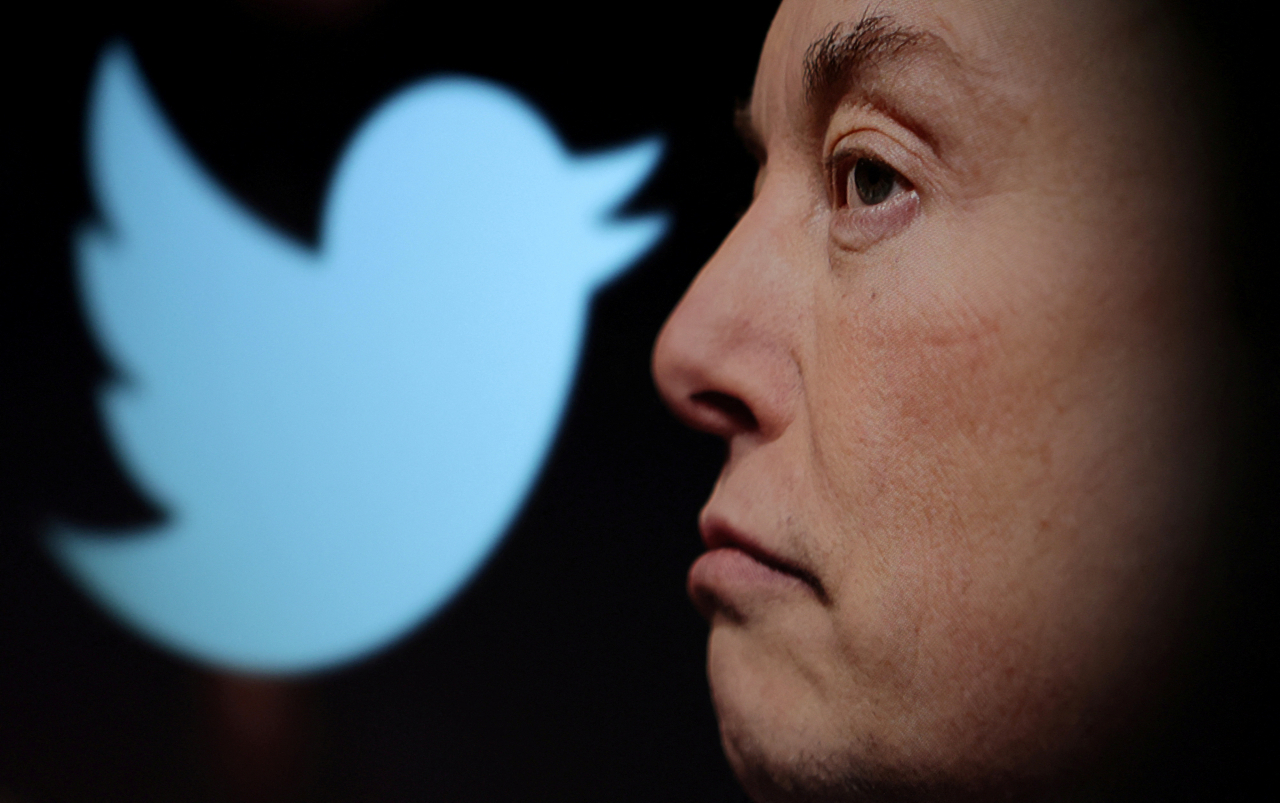 The Twitter logo and a photo of Elon Musk are displayed through a magnifier in this illustration. (Reuters-Yonhap)