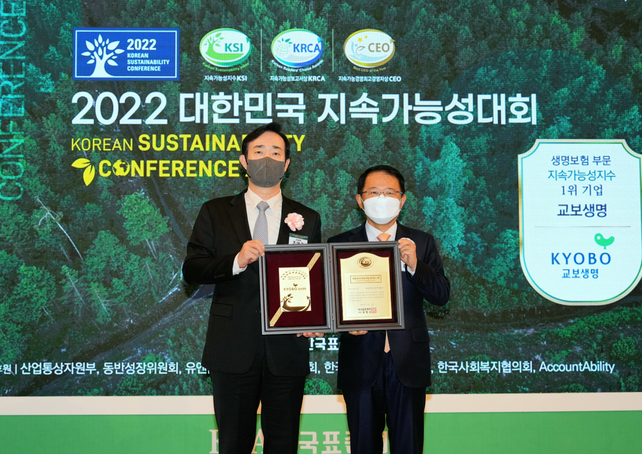 A plaque is awarded to Cho Dae-kyu, head of the Sustainability Management Planning Office of Kyobo Life Insurance (left) on Thursday at the 2022 Korean Sustainability Conference in recognition of the firm ranking first among insurance companies in the Korean Sustainability Index. (Kyobo Life Insurance)