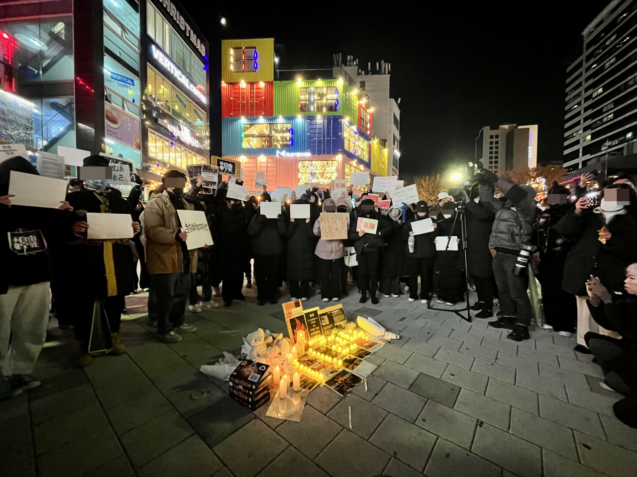 Protesters gather around an altar set up for remembering the victims of a recent deadly fire in Urumqi, the capital of Xinjiang Uyghur Autonomous Region in China, Wednesday. (Kim Arin/The Korea Herald)