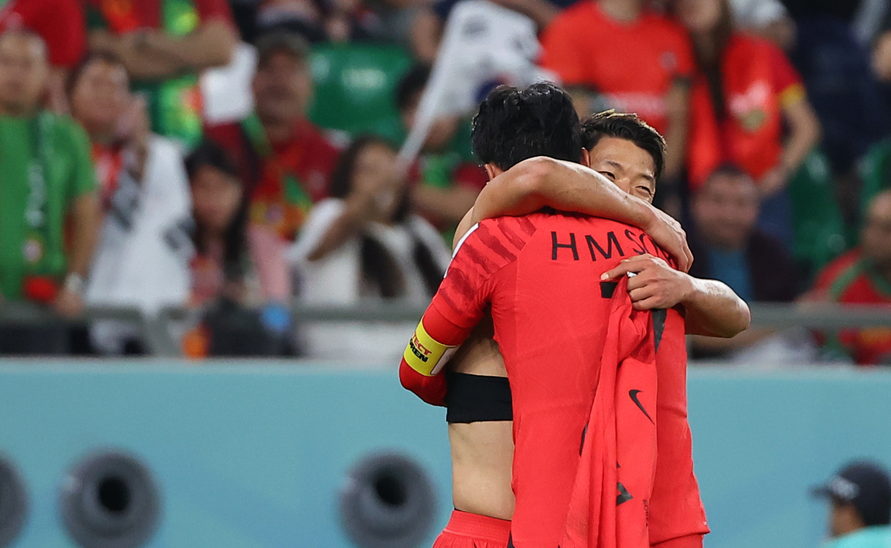 South Korea's Son Heung-min celebrates with Hwang Hee-chan after Hwang scored his team's second goal during the Qatar 2022 World Cup Group H football match between South Korea and Portugal at the Education City Stadium in Al-Rayyan, Qatar on Saturday. (Yonhap)