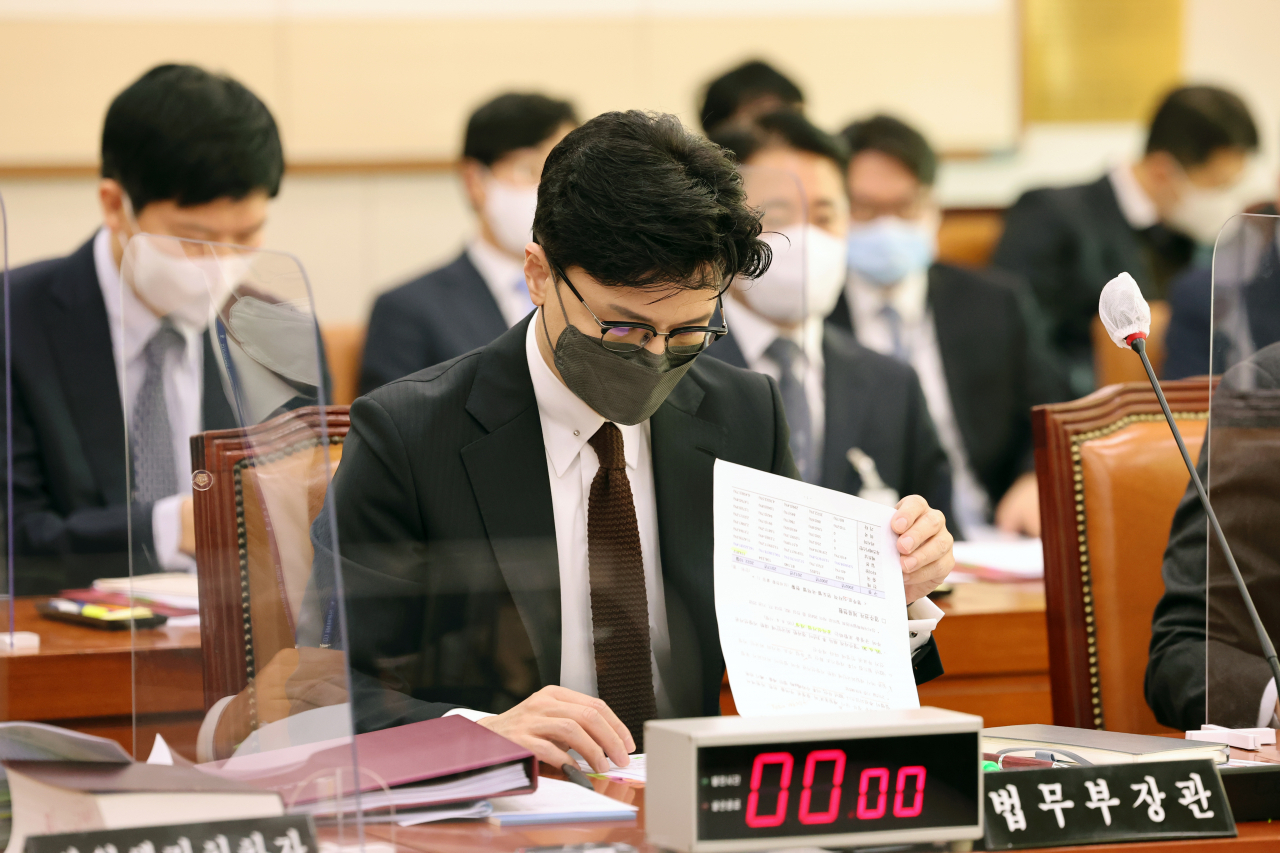 Justice Minister Han Dong-hoon reads documents at the plenary session of the Legislation and Judiciary Committee held at the National Assembly in Seoul, Wednesday. (Yonhap)