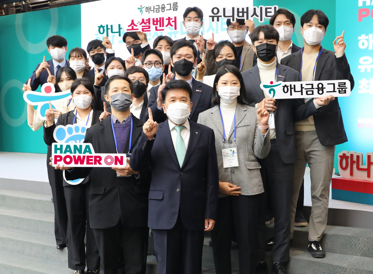 Hana Financial Group Chairman Ham Young-joo (front center) poses for a photo with participants of an event held to share the results of its university student support program on Wednesday at its branch in Myeong-dong, Seoul. (Hana Financial Group)