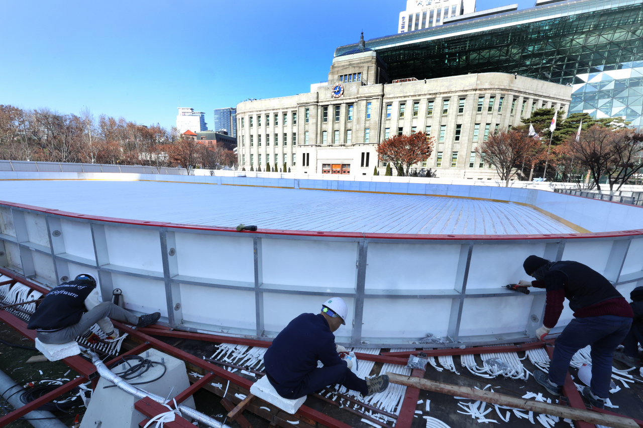 This photo taken on last Sunday, shows a skating rink under construction in front of the Seoul City Hall building in central Seoul. The Seoul city government did not open the skating rink in the past two years due to the COVID-19 pandemic. (Yonhap)