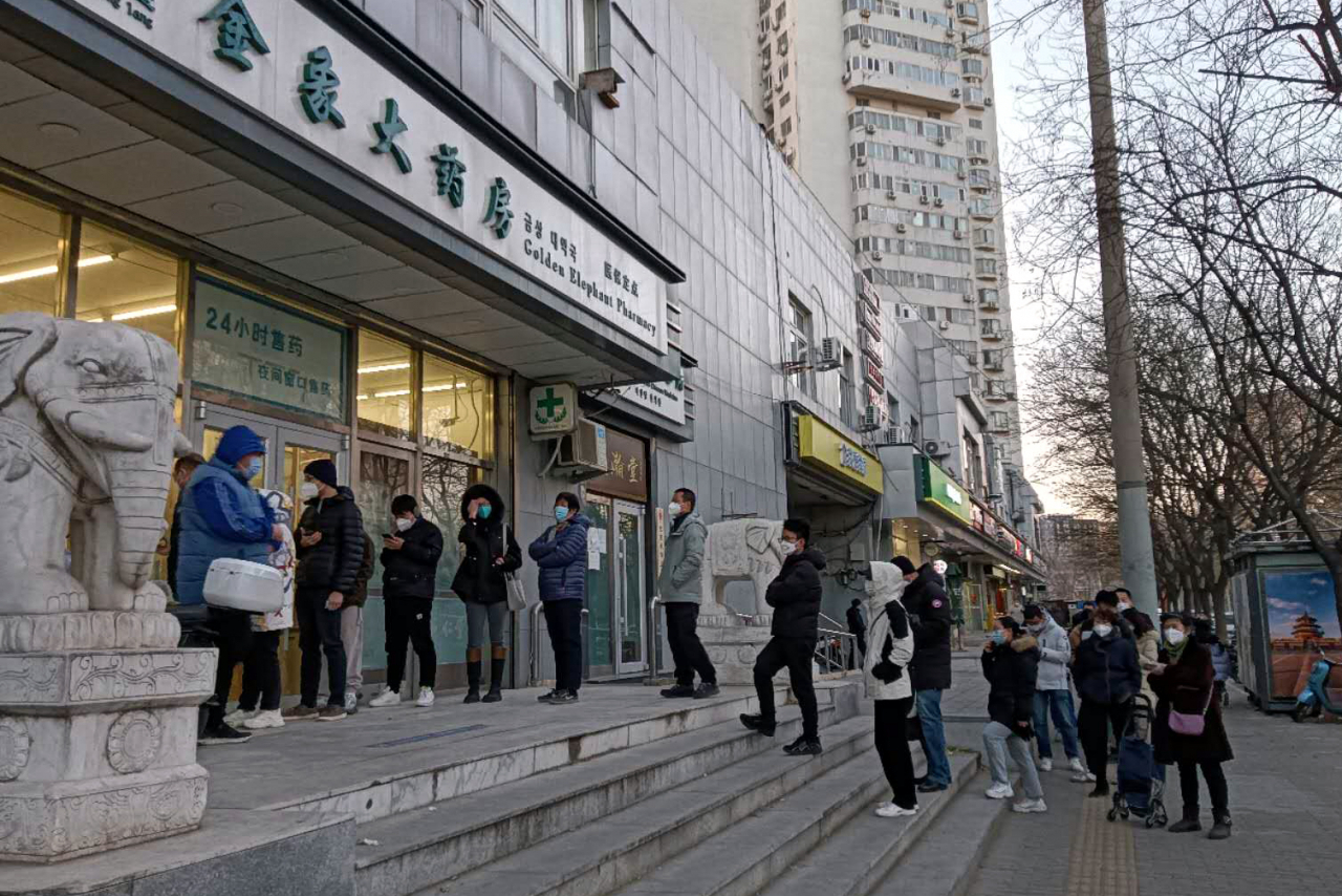 People line up in front of a pharmacy in Beijing, China on Thursday. (Yonhap)