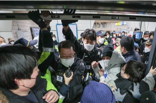 Members of Solidarity Against Disability Discrimination clash with security officers during a protest on the platform at Seoul's Samgakji Station on Line No. 4 on Dec. 2. (Yonhap)