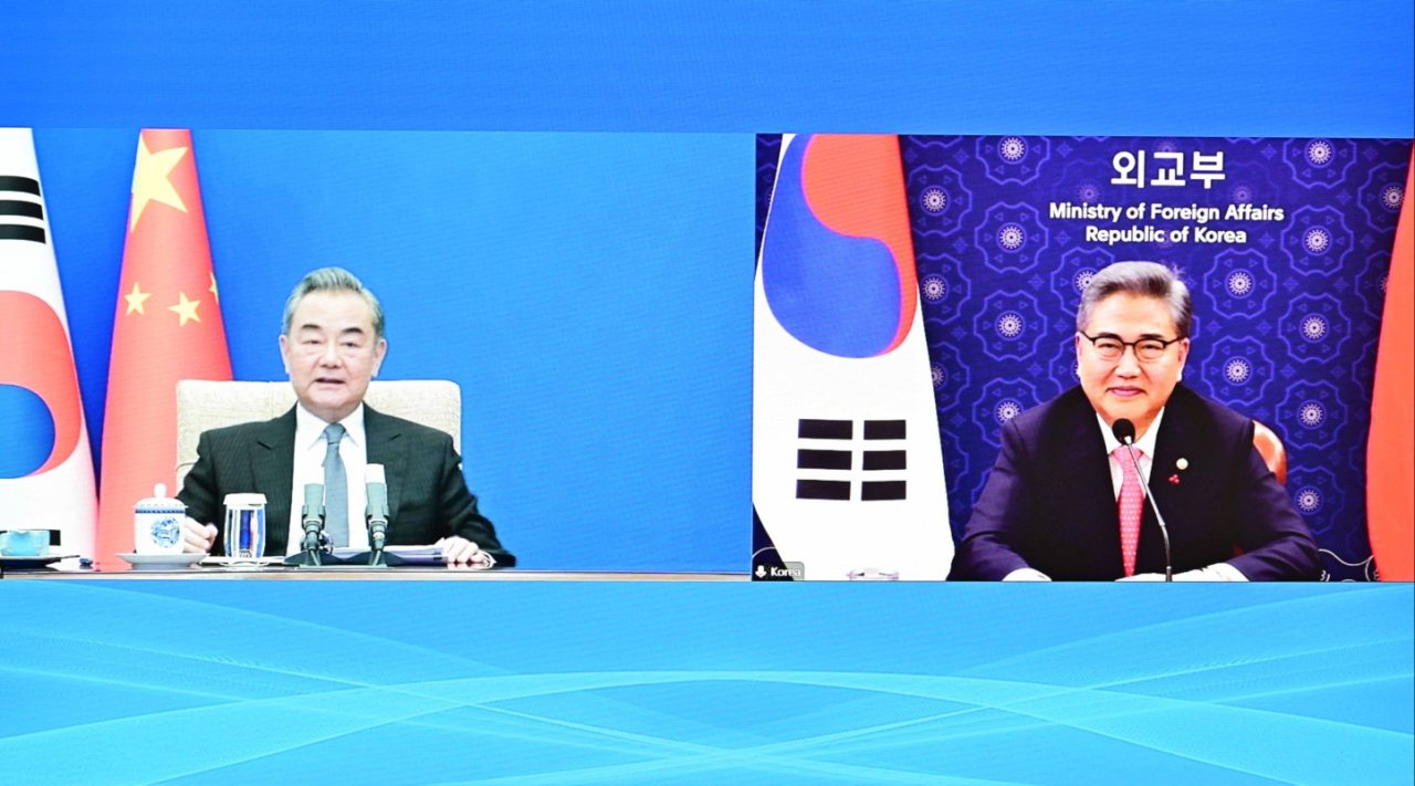 Foreign Minister Park Jin (right) and his Chinese counterpart hold a videoconference on Monday. (Ministry of Foreign Affairs)
