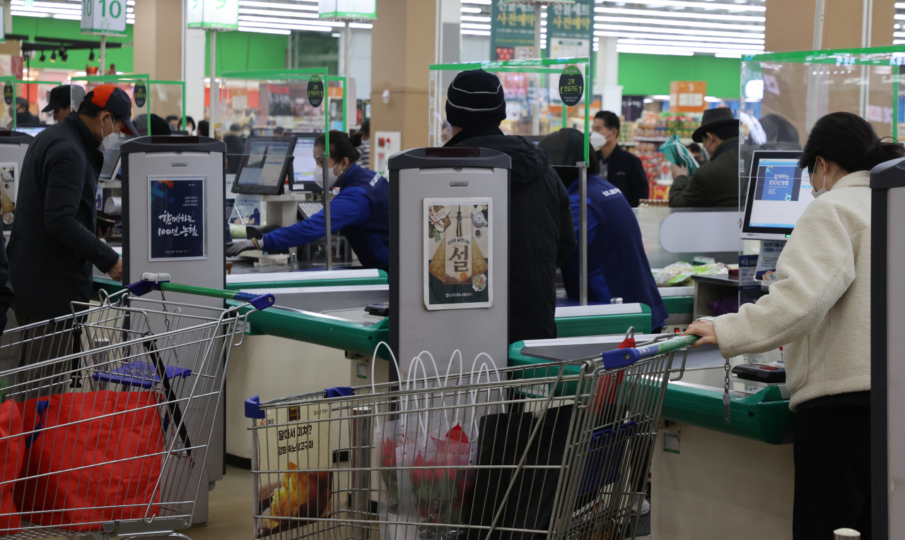 People pay for their purchases at a large discount store chain in Seoul amid eased COVID-19 virus curbs on Thursday. (Yonhap)