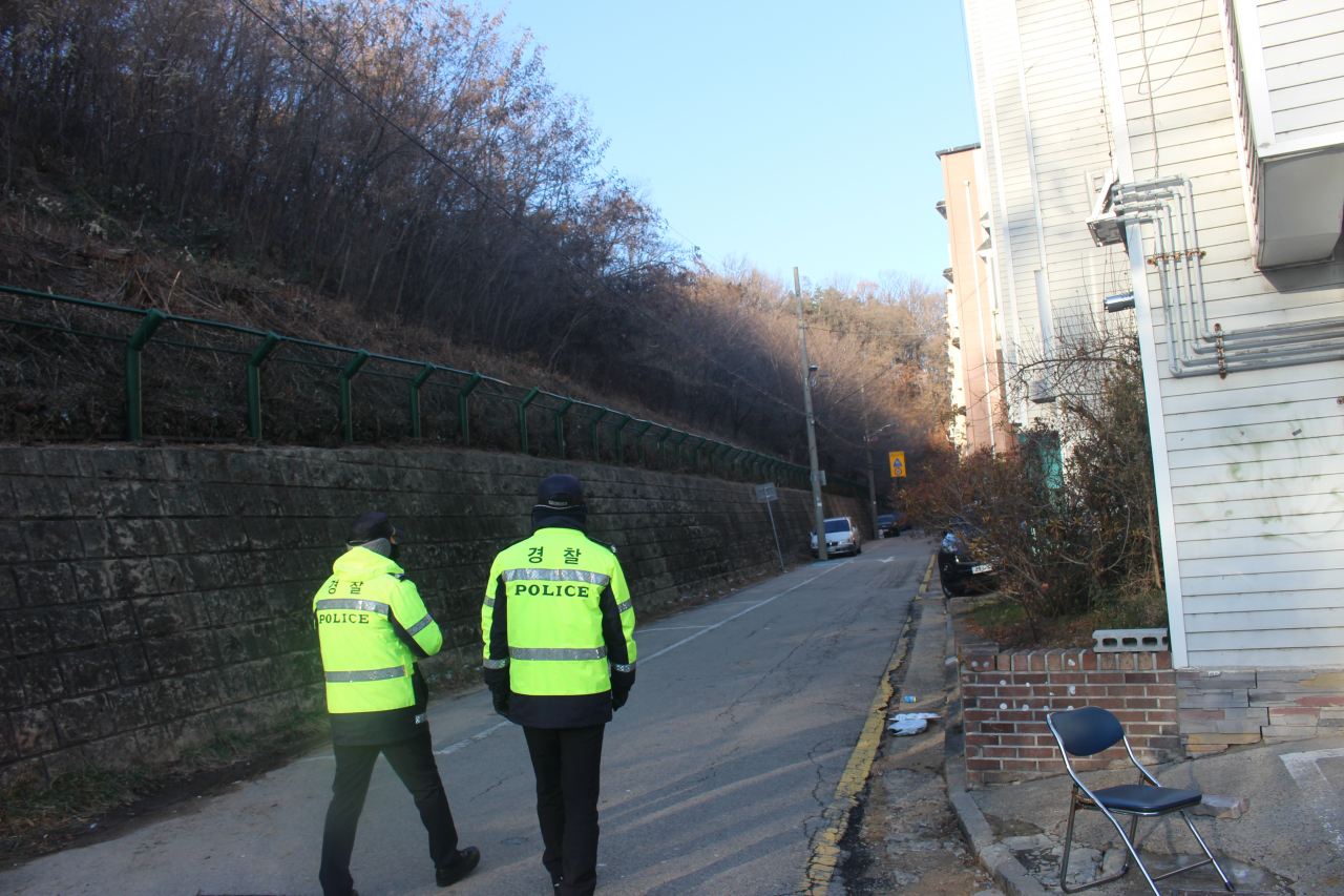 Police officers patrol the area around convicted child rapist Cho Doo-soon's home in in Wa-dong, Ansan, Gyeonggi Province. Yoon Min-sik/The Korea Herald