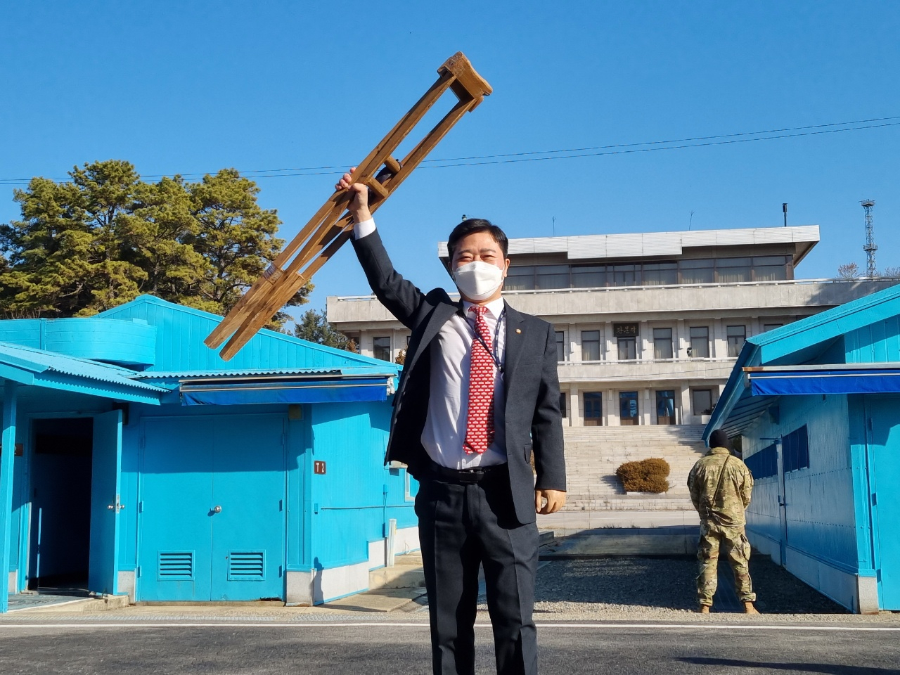 Defector-turned-lawmaker Rep. Ji Seong-ho hoists the crutches he depended on throughout his journey out of North Korea at the Panmunjom border village, on Dec. 22, 2021. (Courtesy of Ji)