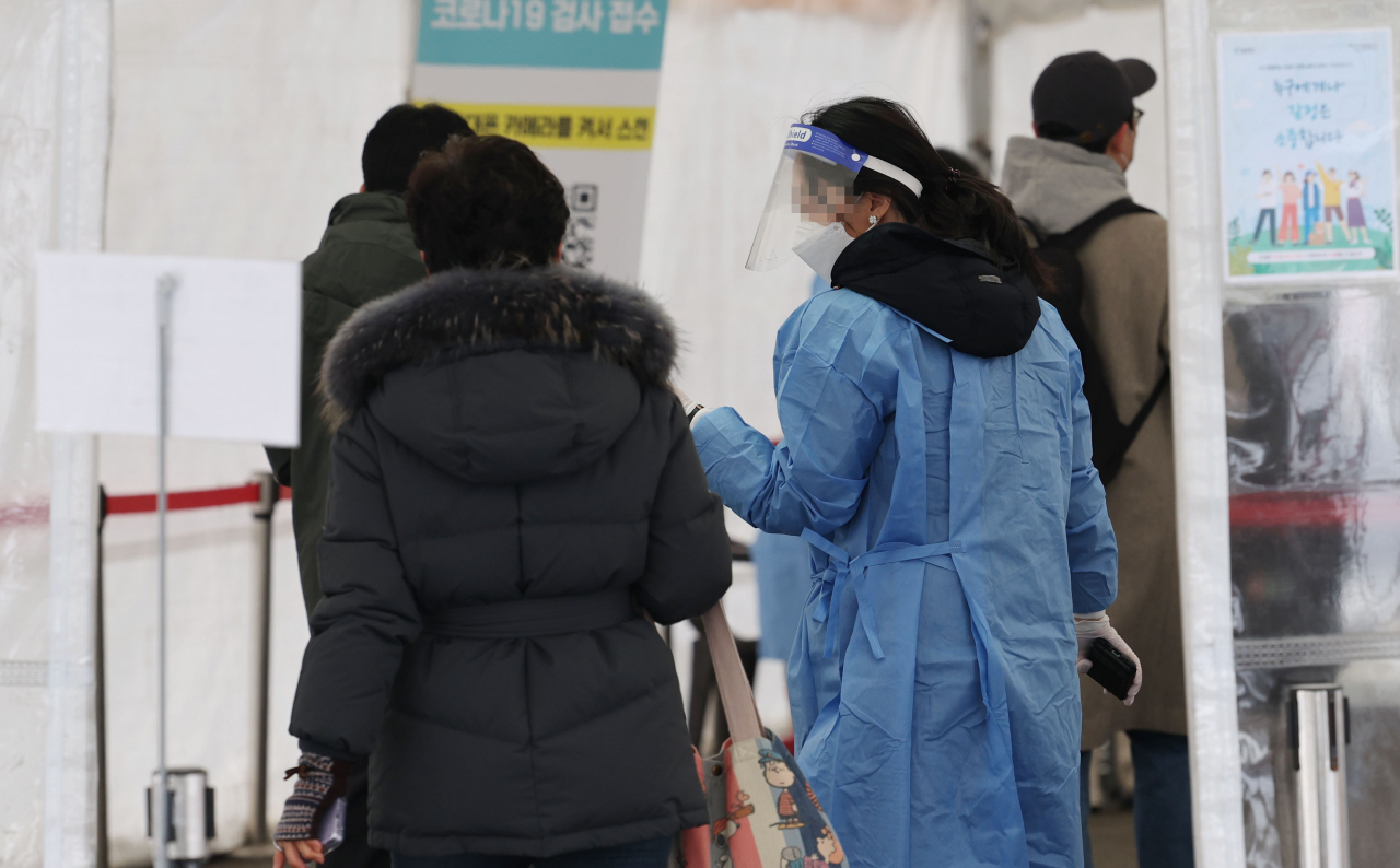 A medical worker guides a visitor in a COVID-19 testing booth at Seoul Station in Seoul on Wednesday. (Yonhap)