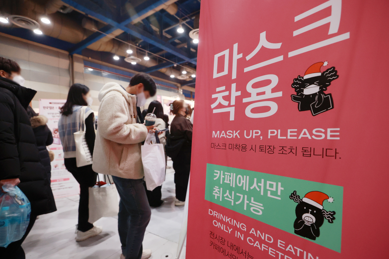 A sign at an exhibition in Seoul on Thursday asks visitors to keep their face masks on. (Yonhap)