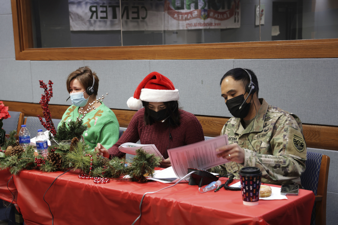 In this photo released by the U.S. Department of Defense, volunteers answer phones and emails from children around the globe during annual NORAD Tracks Santa event at Peterson Air Force Base in Colorado Springs, Colo., on Saturday. (AP-Yonhap)