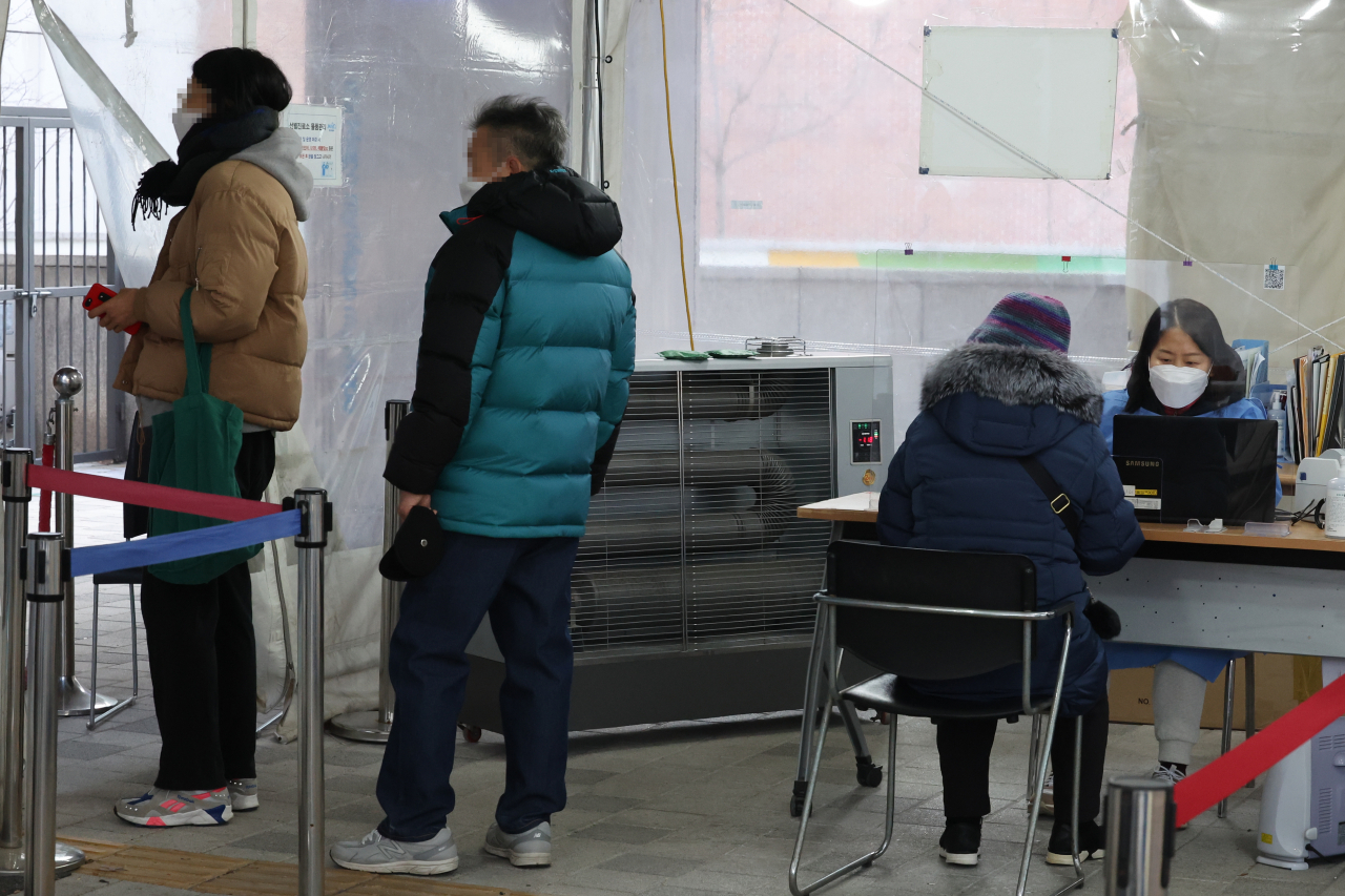 People wait in line to get tested for the coronavirus at a testing center in the western ward of Mapo, Seoul, on Monday. (Yonhap)