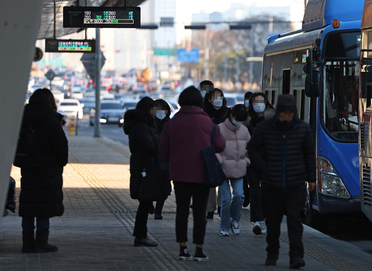 Pedestrians are seen at a bus stop in Yeouido, Seoul on Thursday. (Yonhap)