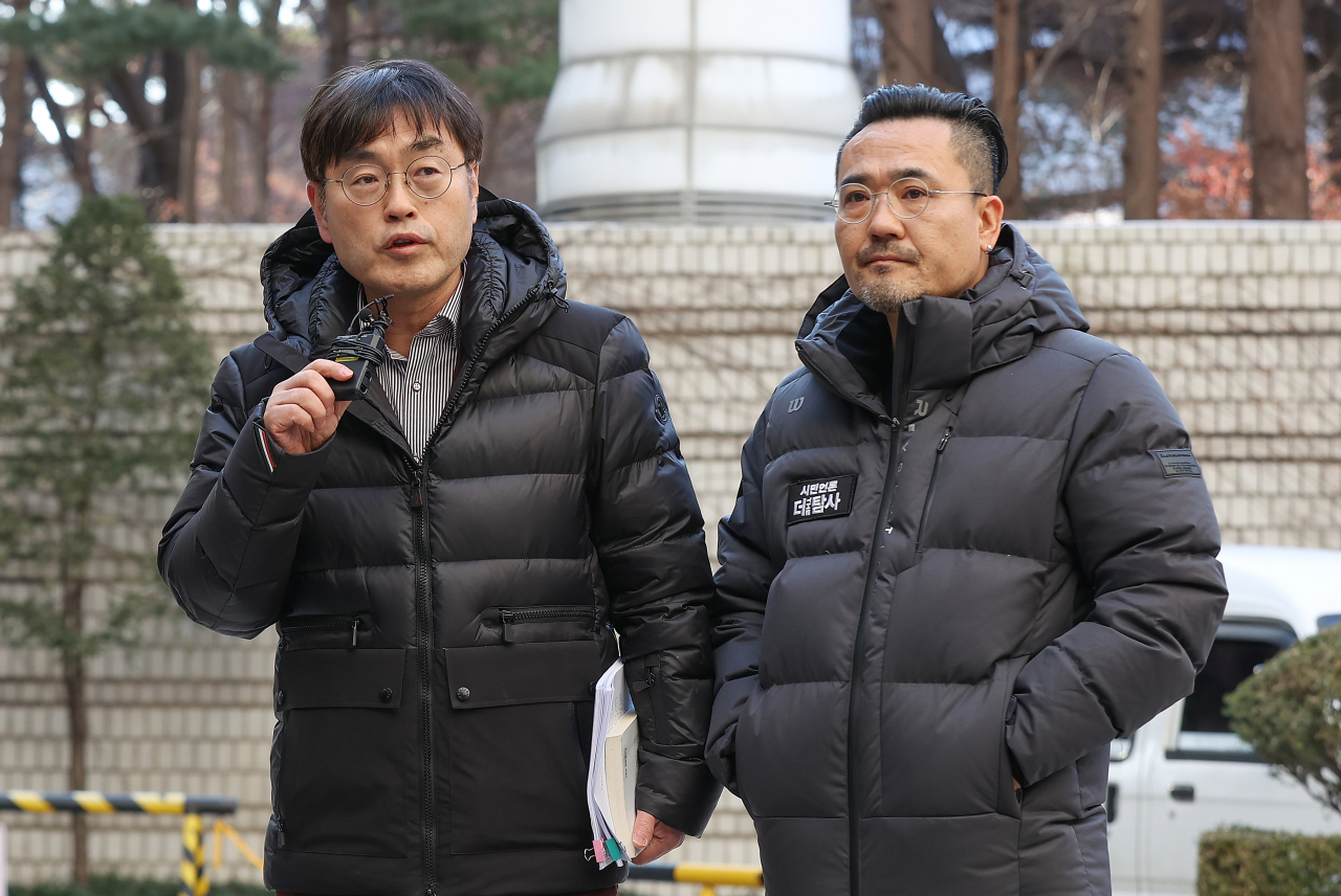 Reporters from Citizen Press The Tamsa TV, Kang Jin-koo (left), and Choi Young-min, talk to reporters before attending a court hearing on Thursday. (Yonhap)