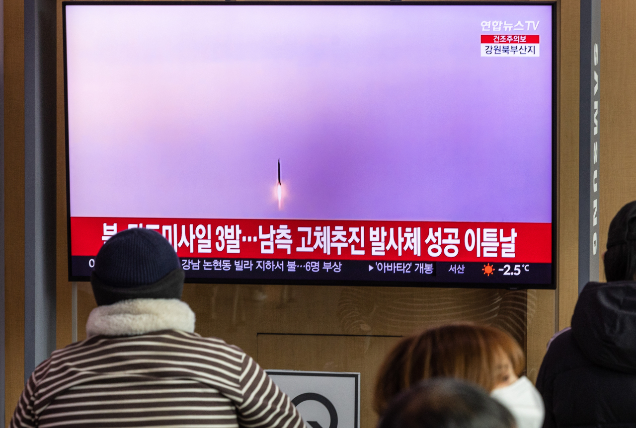 People watch news of North Korea firing three ballistic missiles at Seoul Station on Saturday. (Yonhap)